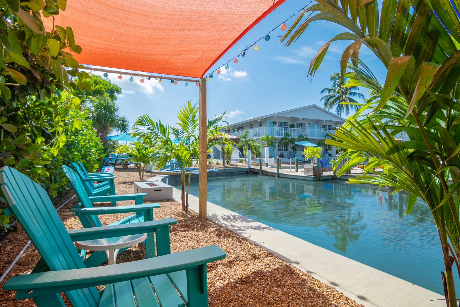 Turquoise waterfront lounge chairs, palms and docks at Latitude 26 Waterfront Boutique Resort